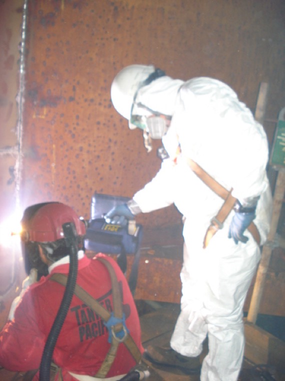 Personnel in full PPE monitoring for mercury vapour