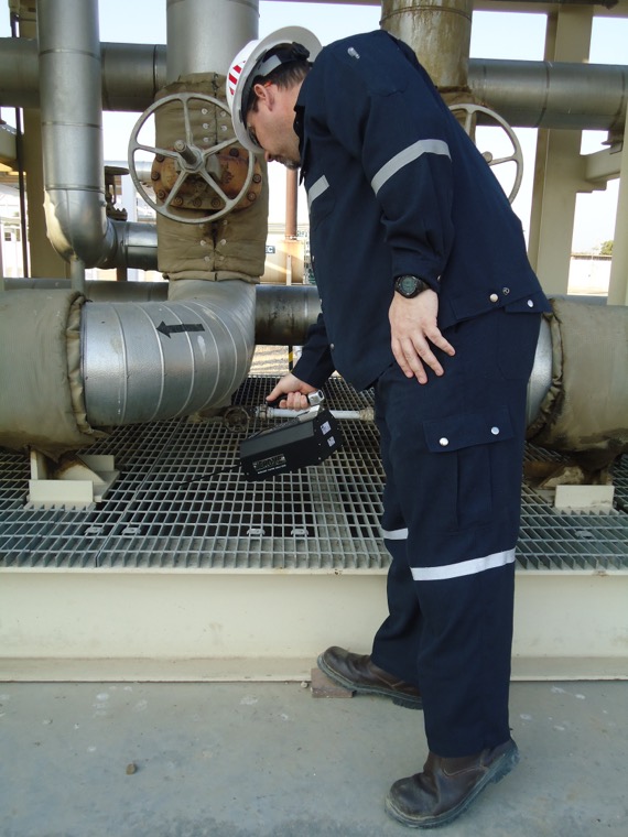 Technician surveying pipework
